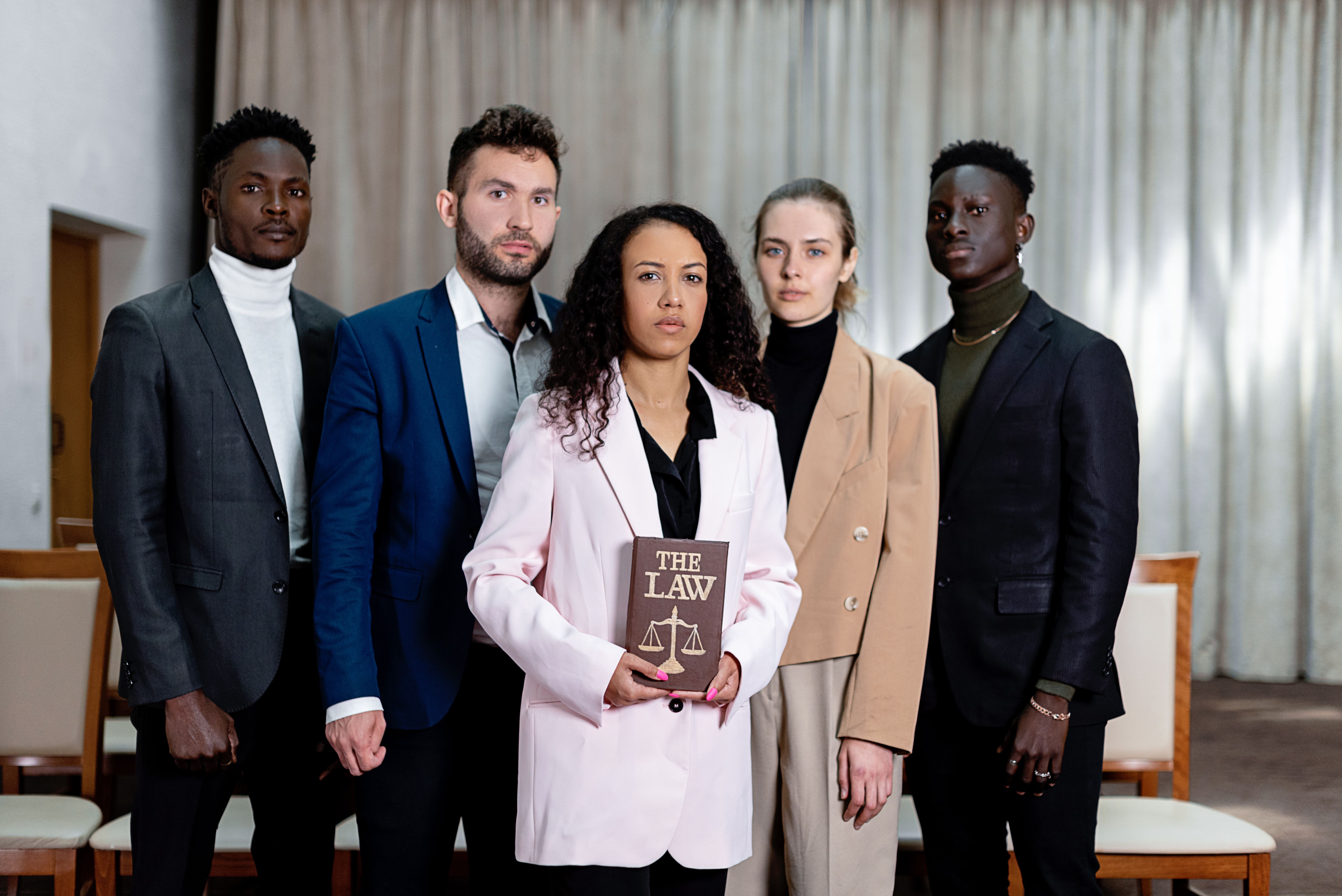 A diverse team of legal professionals standing together in an office.
