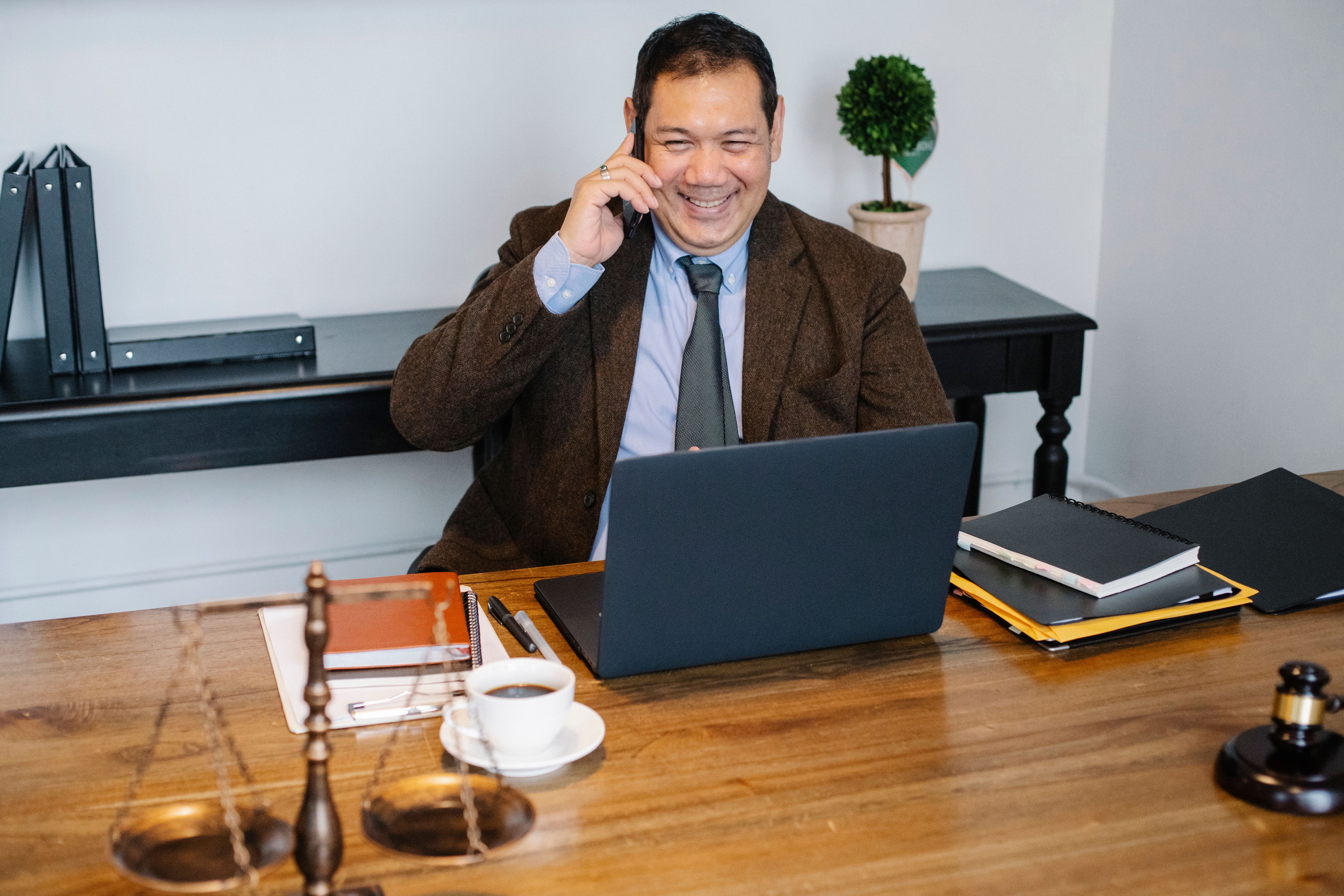 A business professional on a call at a laptop in a legal office.